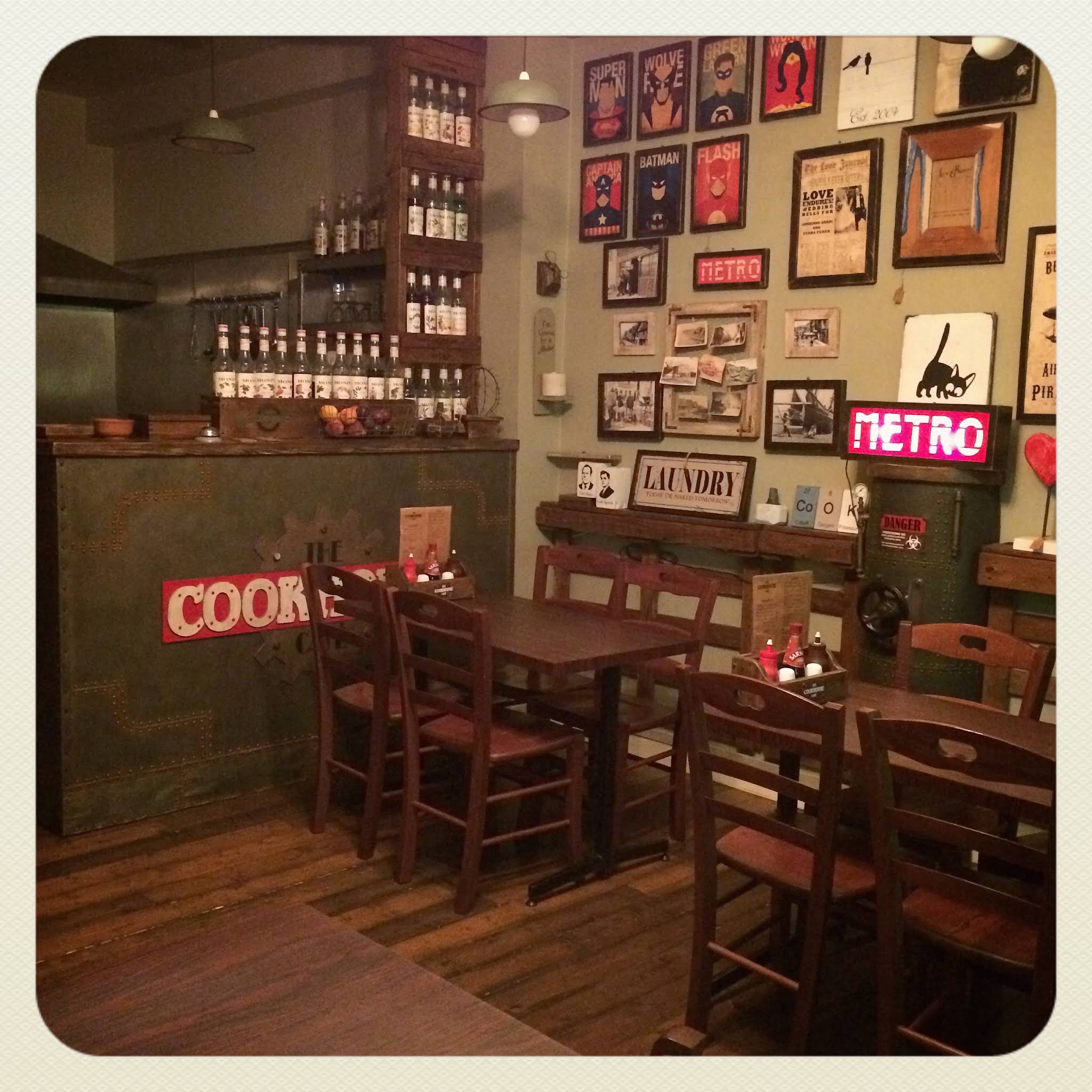 Historic Cookhouse interior with wooden tables, chairs, counter and a wall of framed posters